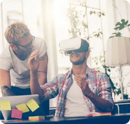 Two developers testing VR-based blockchain game in modern office